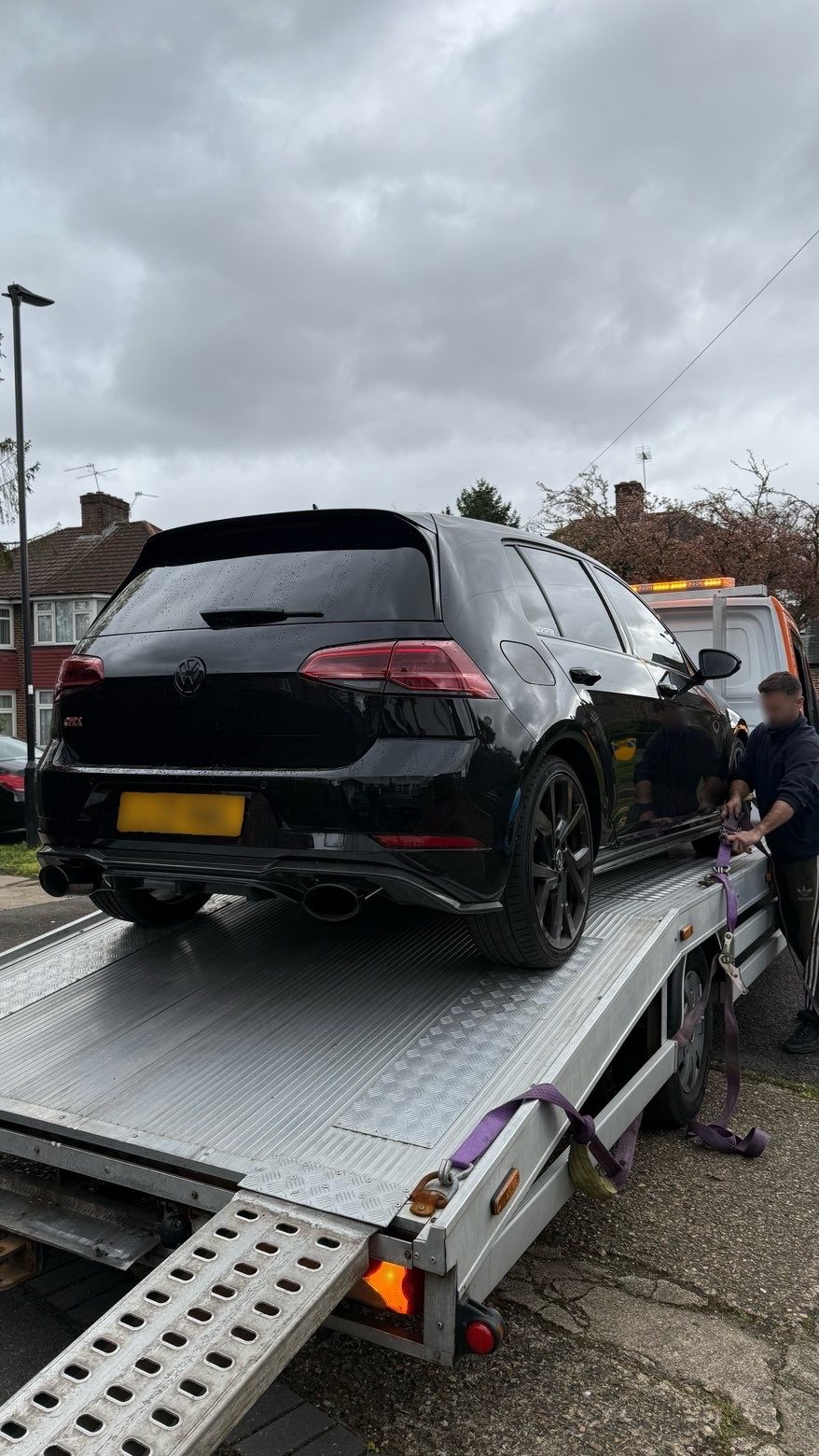 Black Volkswagen Golf secured on recovery flatbed